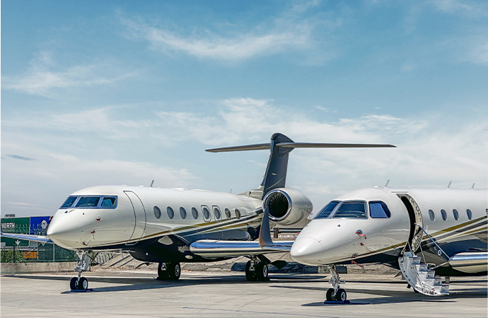 Two private Air Partner planes side by side on a runway 